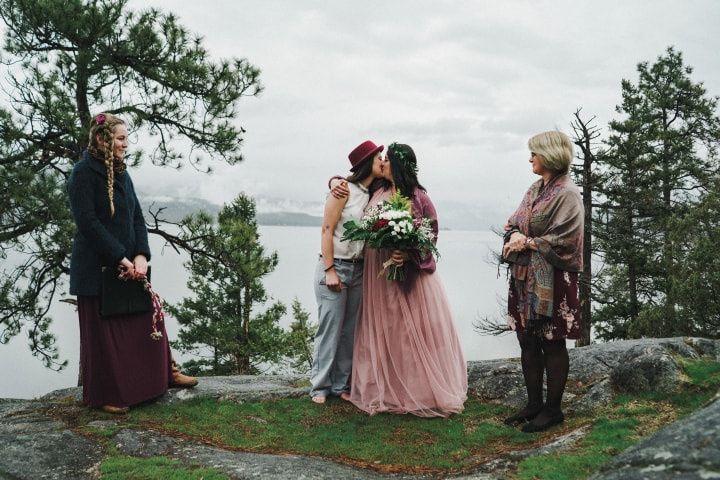 Brides kissing at gay wedding ceremony 