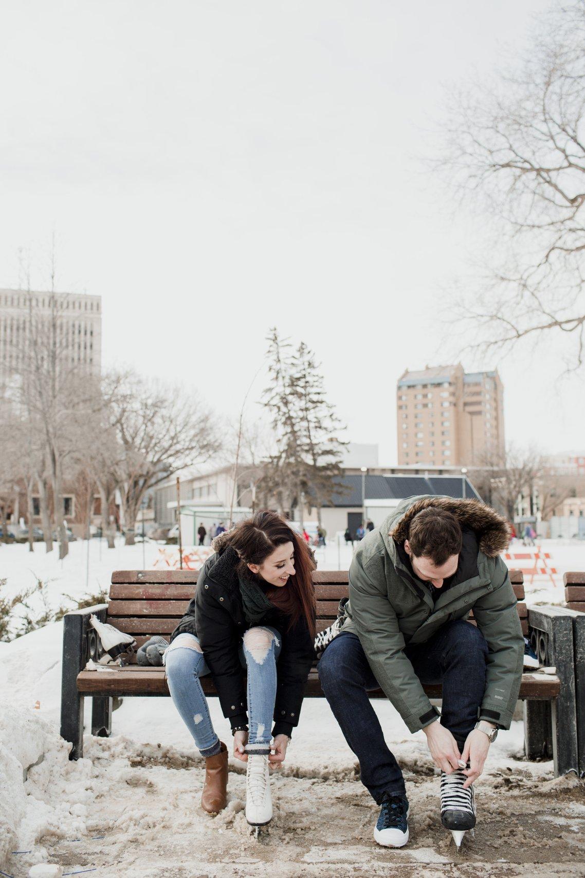 Outdoor portrait. Young beautiful happy smiling couple posing on street.  Models hugging, looking at candy canes, wearing stylish winter clothes.  Snowfall. City lifestyle. Copy, empty space for text Stock Photo | Adobe