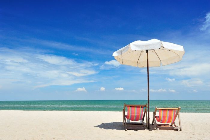 Two Lounge Chairs and Umbrella on Beach