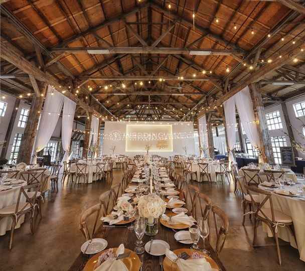 reception venue table setting string lights rustic barn