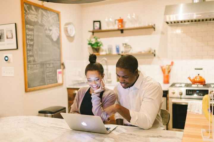 couple browsing on laptop in kitchen