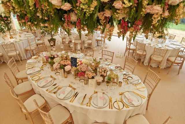oval shaped wedding table with flowers and greenery