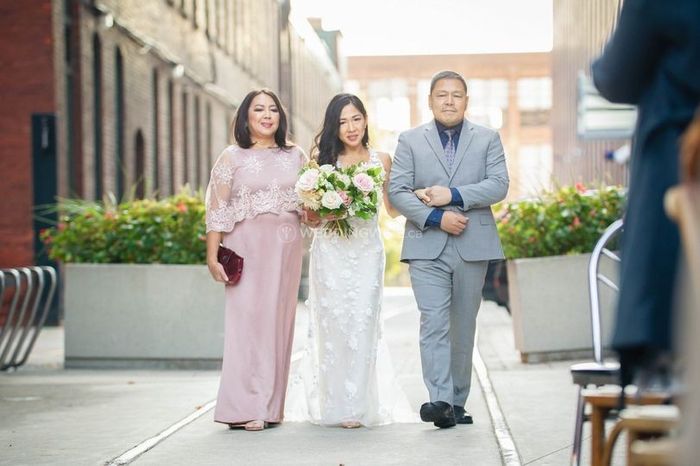 mother and father walk bride down the ailse