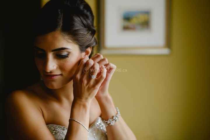 Bride putting in earrings
