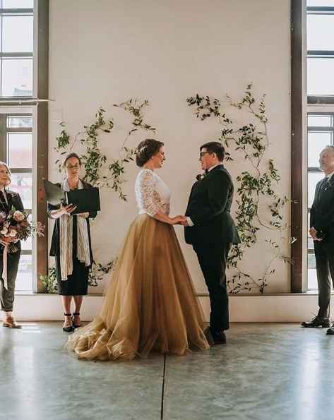 same sex wedding ceremony with floral backdrop