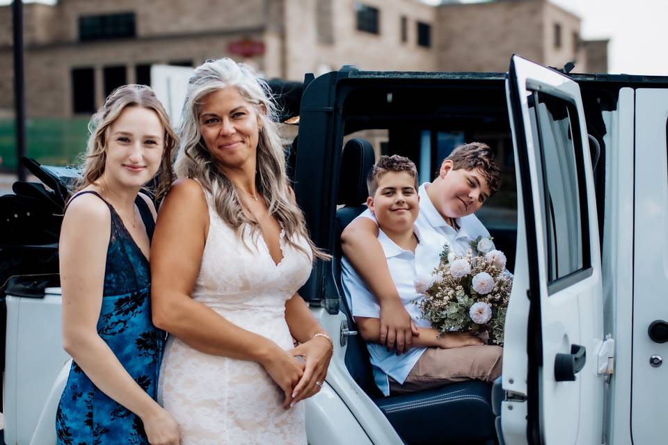 Bride and kids in and on jeep