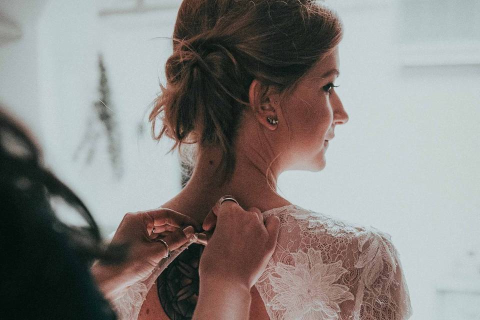 Bride putting on wedding dress