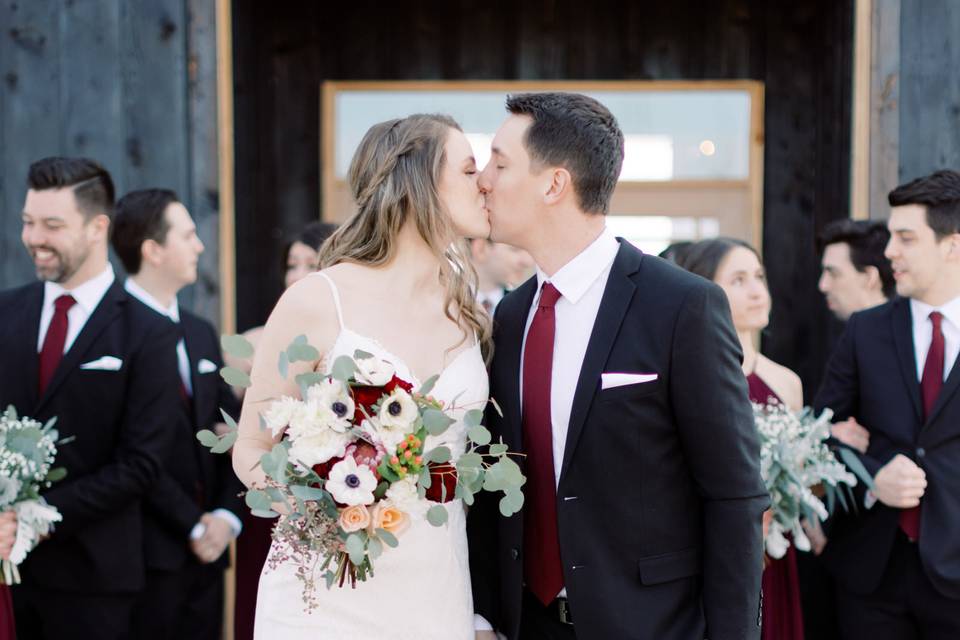 Couple kissing infront of barn