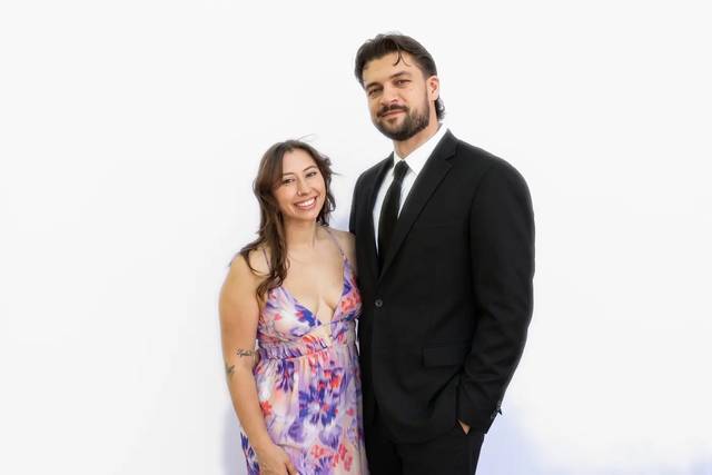 A couple in their wedding best at the Aura booth