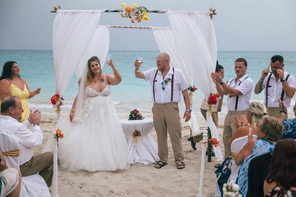 Beach wedding couple toasting