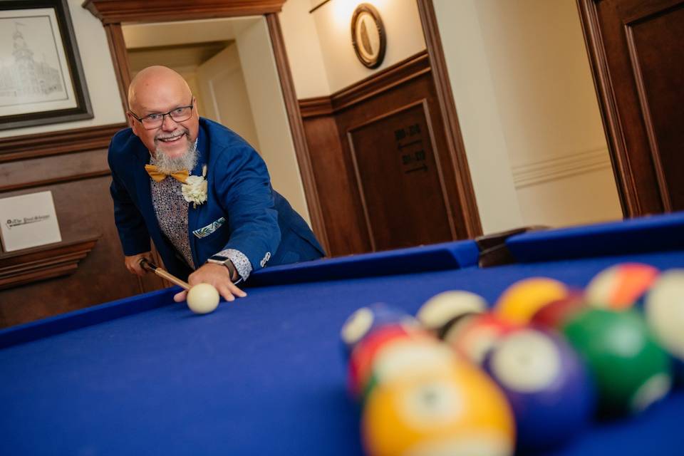 Groom playing pool