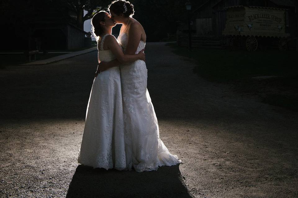 Two brides kiss at night