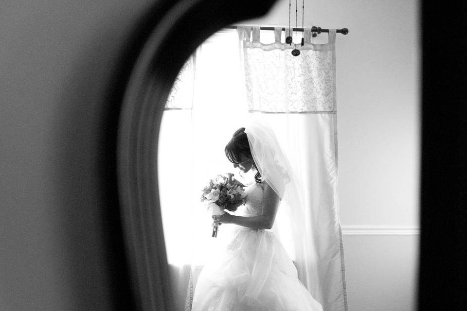 Bride with bouquet at window