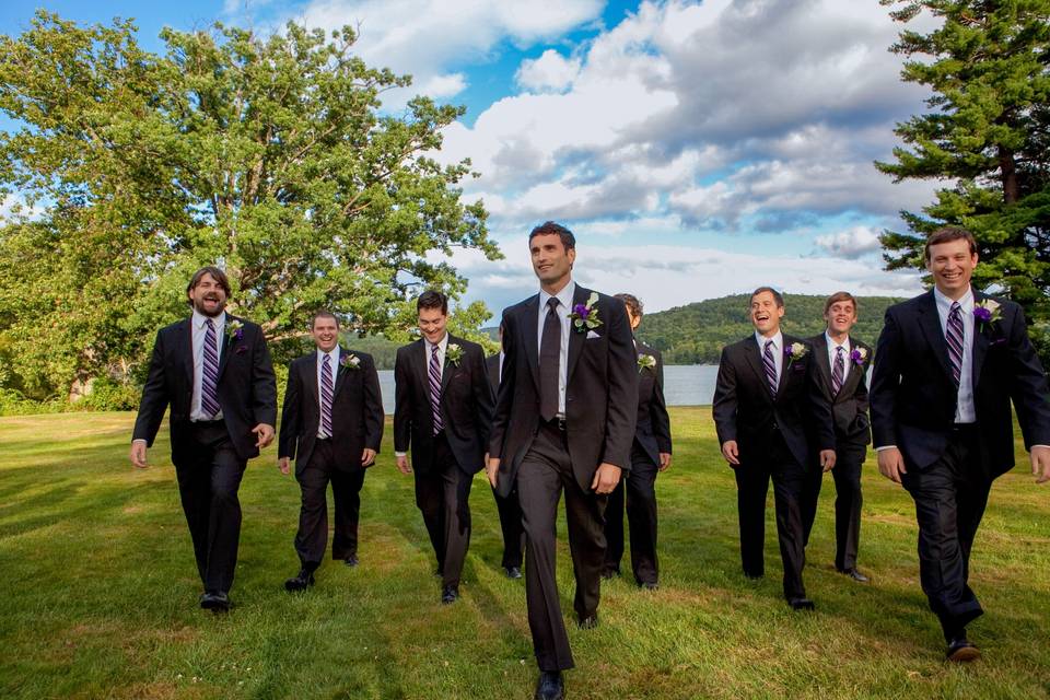 Groom leads groomsmen from lak