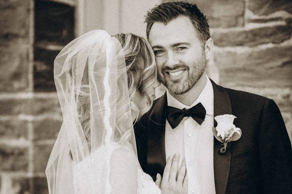 Groom smiles in BW closeup of