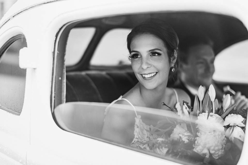 The bride looks out from a car