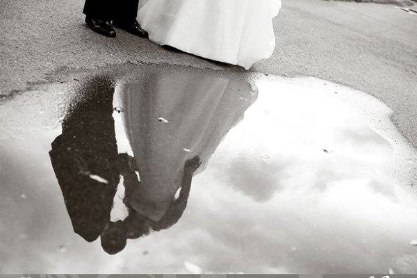 Bride and groom reflection in a puddle.jpeg
