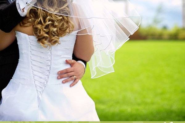 Closeup of the groom's hand on the bride's back.jpeg