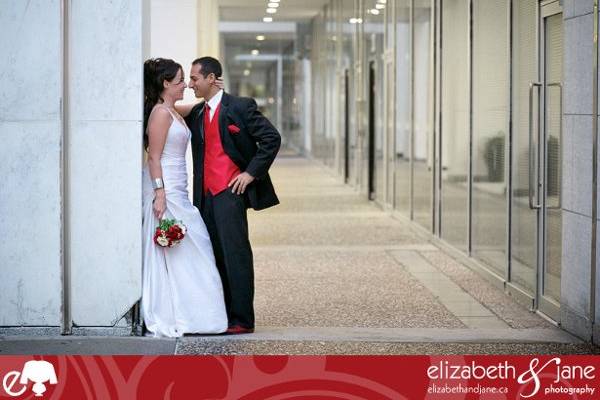 Wedding Photo? bride and groom leaning against a grey wall looking at each other.jpeg