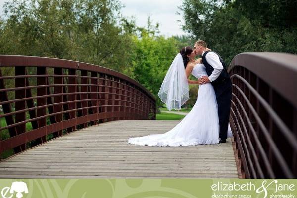 Wedding Photo? couple standing on a bridge kissing.jpeg