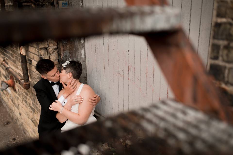 Brides kiss under fire escape