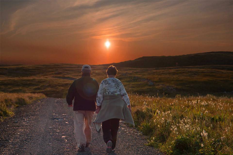 Couple walk in the sunset.