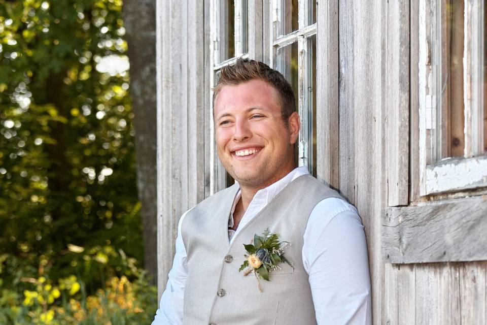 Groom Leans Against Barn