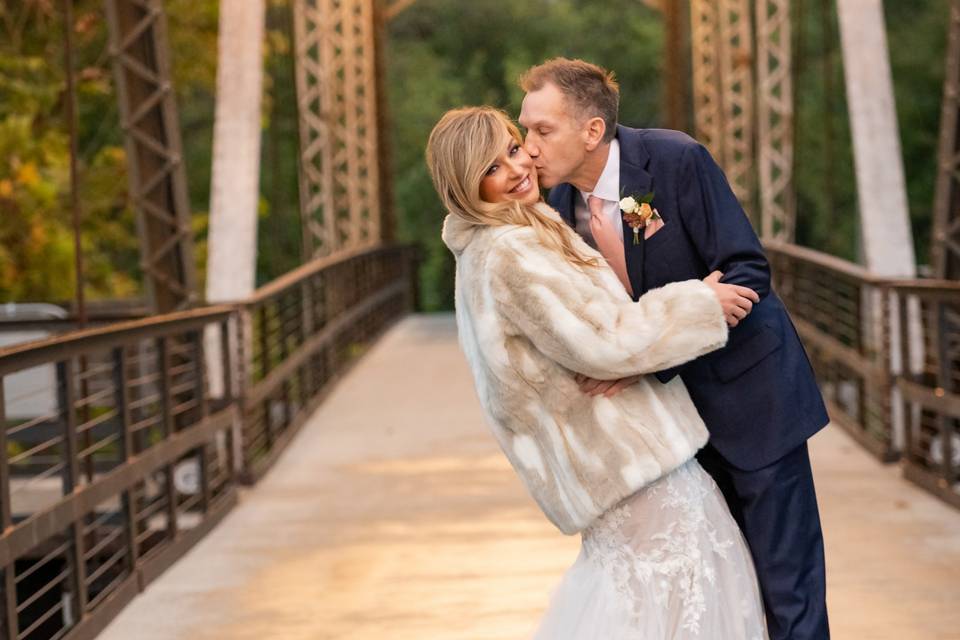 Newlyweds kiss on bridge