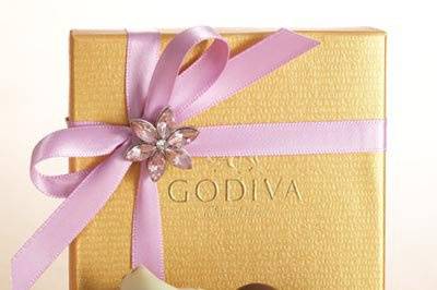 Gold favor with lilac ribbon and flower