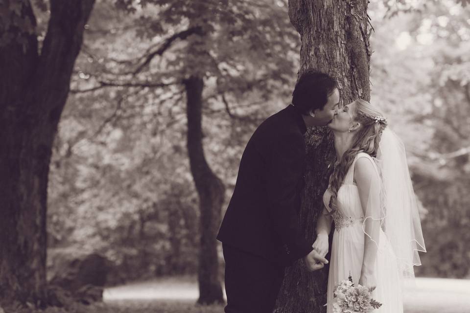 Bride and groom kiss forest