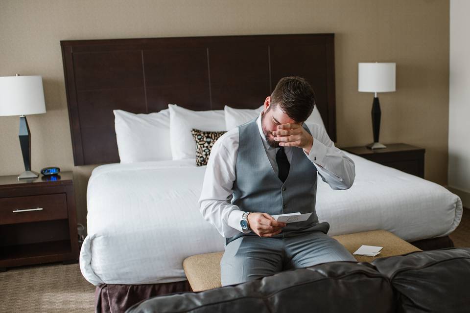 Groom crying at letter.