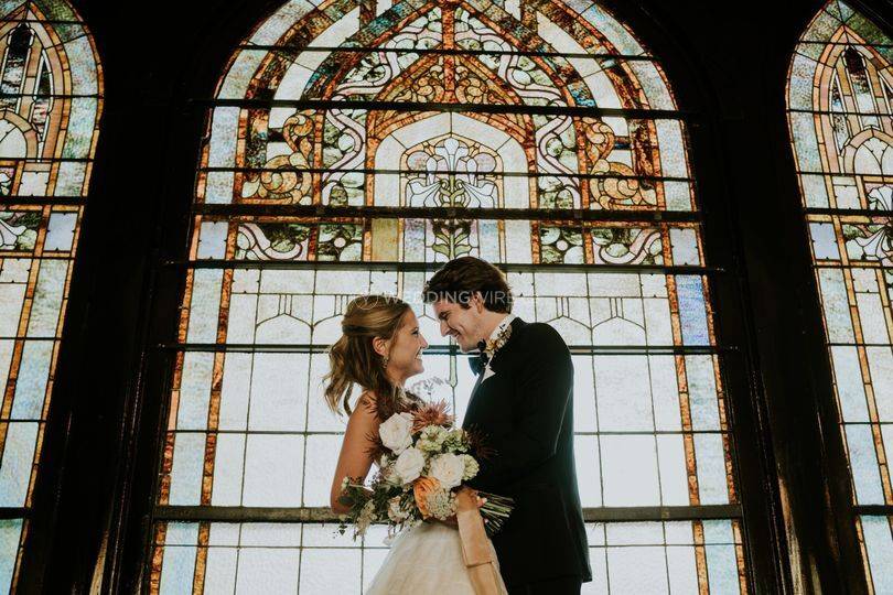 Couple by stained glass - Neville Wedding Stories