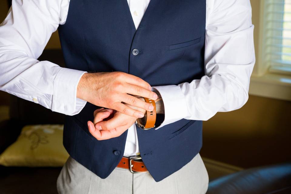 Groom putting on suit & watch