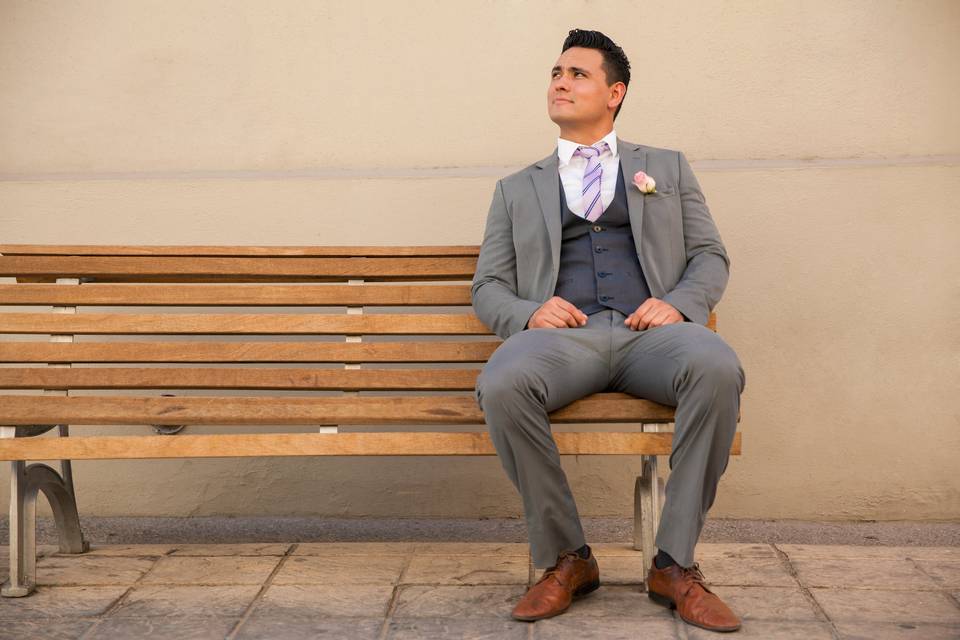 Groom in suit sitting on bench