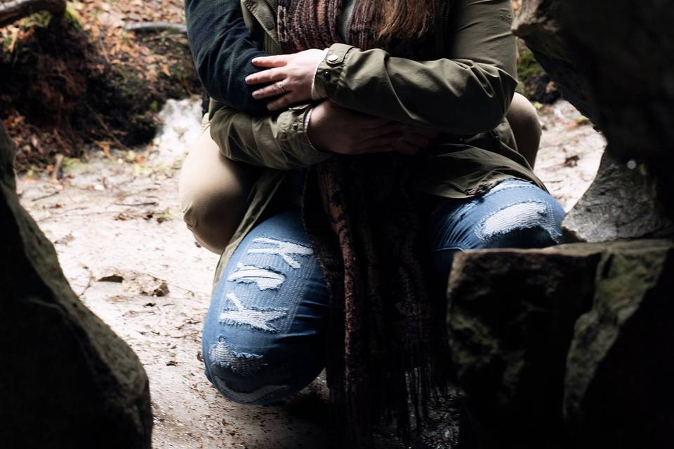 Couple framed in cave hugging