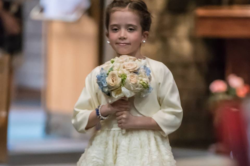 Child walking down aisle with flowers