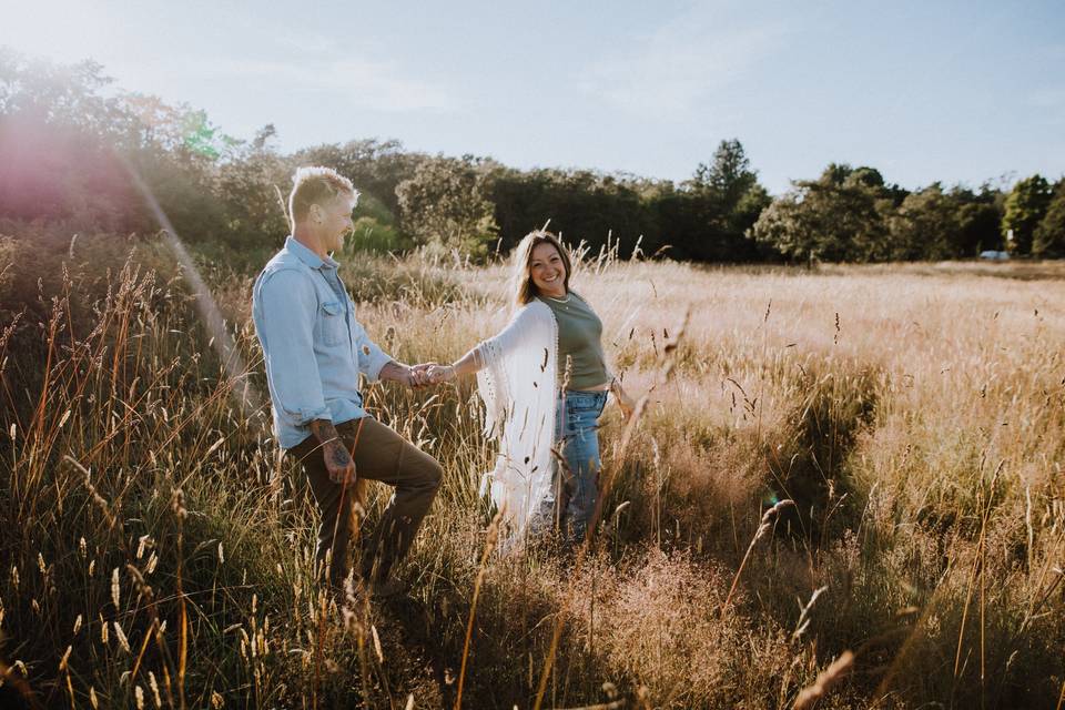 Couple holding hands in field